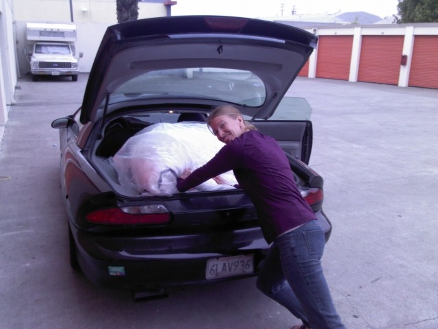 Alena stuffing mattress into Camaro